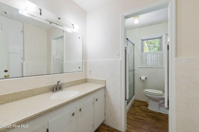 263 La Grange Rd, La Grange, NC 28551 - bathroom with wood finished floors, toilet, vanity, tile walls, and a stall shower