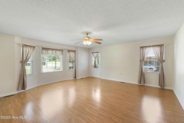 263 La Grange Rd, La Grange, NC 28551 - empty room featuring a ceiling fan, light wood-type flooring, plenty of natural light, a textured ceiling, and baseboards