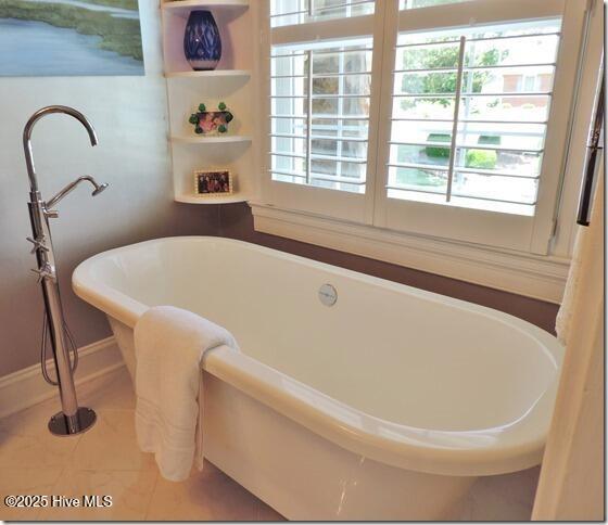 110 E Blalock Rd, Lucama, NC 27851 - bathroom featuring healthy amount of natural light, a soaking tub, tile patterned floors, and baseboards