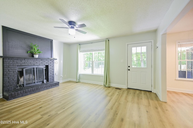 159 Dockside Dr, Jacksonville, NC 28546 - unfurnished living room with wood finished floors, a textured ceiling, healthy amount of natural light, a ceiling fan, and a brick fireplace