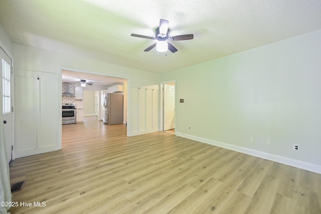 159 Dockside Dr, Jacksonville, NC 28546 - unfurnished living room with a ceiling fan, light wood finished floors, baseboards, and a textured ceiling