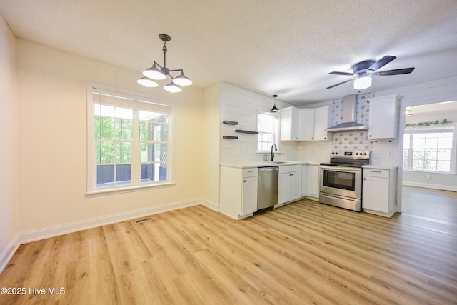 159 Dockside Dr, Jacksonville, NC 28546 - kitchen featuring appliances with stainless steel finishes, wall chimney exhaust hood, light wood-type flooring, plenty of natural light, and a textured ceiling