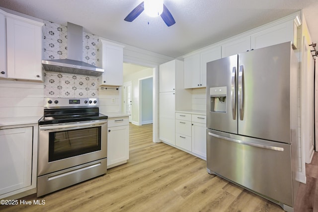 159 Dockside Dr, Jacksonville, NC 28546 - kitchen featuring appliances with stainless steel finishes, wall chimney range hood, light countertops, light wood finished floors, and ceiling fan