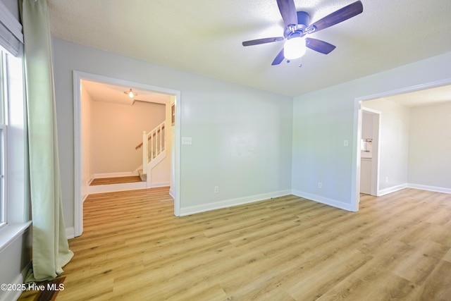 159 Dockside Dr, Jacksonville, NC 28546 - empty room featuring light wood-type flooring, ceiling fan, stairs, and baseboards