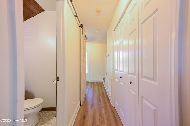 159 Dockside Dr, Jacksonville, NC 28546 - hall featuring light wood finished floors, a barn door, and baseboards