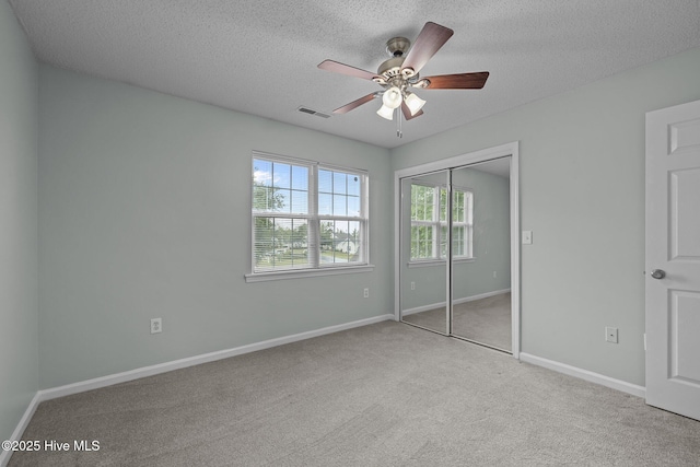 202 Courtyard W, Newport, NC 28570 - unfurnished bedroom with carpet, a closet, a textured ceiling, and a ceiling fan
