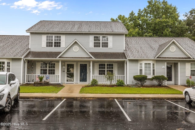 202 Courtyard W, Newport, NC 28570 - traditional-style house with covered porch, a shingled roof, uncovered parking, and a front lawn