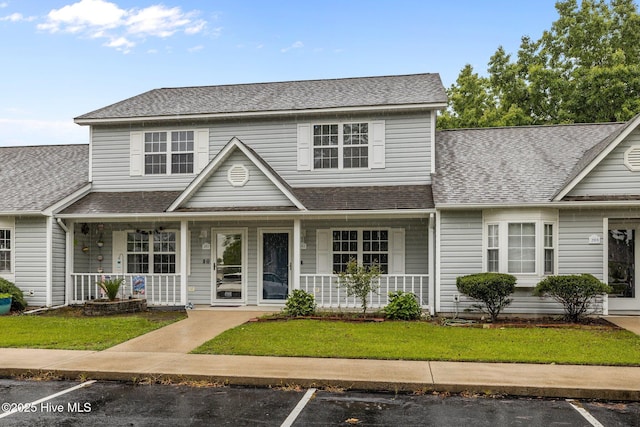 202 Courtyard W, Newport, NC 28570 - traditional-style home featuring covered porch, uncovered parking, a shingled roof, and a front yard