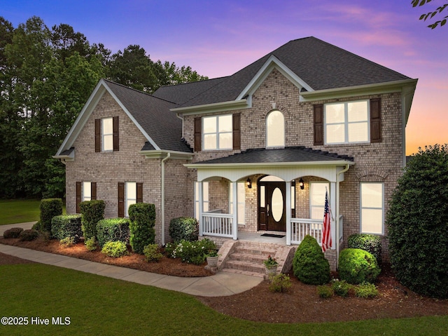 3107 Indian Wells Pl, Greenville, NC 27858 - view of front facade with a porch, brick siding, and roof with shingles