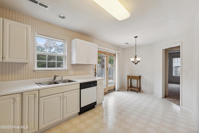 6814 Lipscomb Dr, Wilmington, NC 28412 - kitchen with white dishwasher, a sink, light countertops, baseboards, and a textured ceiling