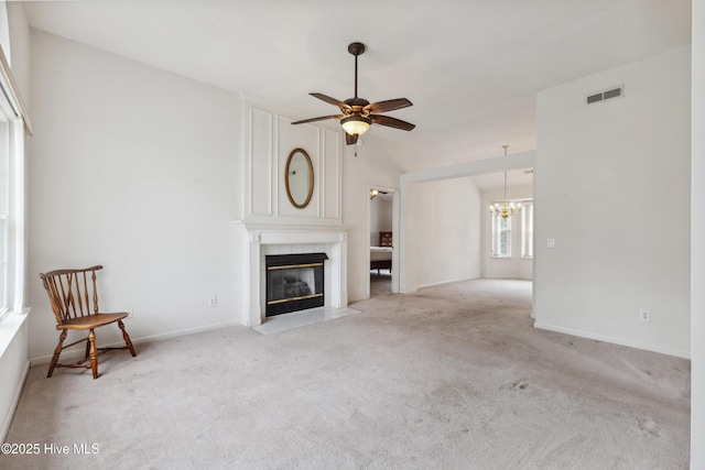 6814 Lipscomb Dr, Wilmington, NC 28412 - unfurnished living room with a tiled fireplace, light carpet, a chandelier, ceiling fan, and baseboards