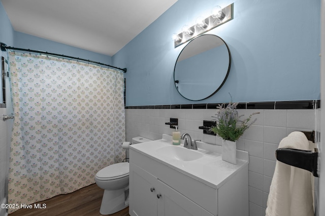 210 Glenburnie Dr, New Bern, NC 28560 - bathroom featuring wood finished floors, vanity, toilet, tile walls, and a wainscoted wall