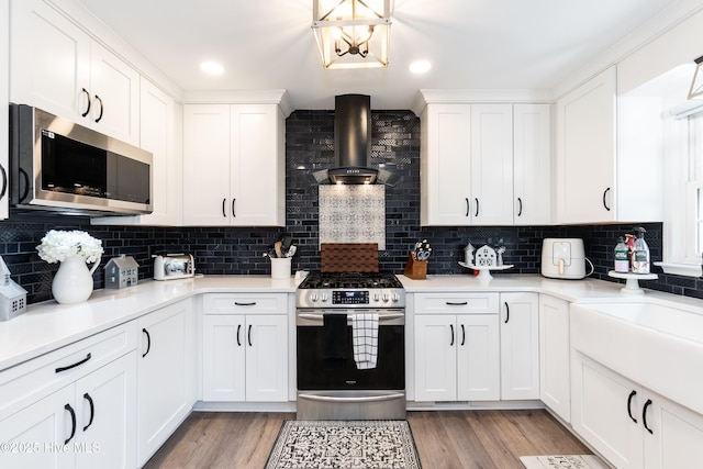 103 Midway Ln, Roanoke Rapids, NC 27870 - kitchen with stainless steel appliances, wall chimney range hood, backsplash, light wood finished floors, and white cabinetry
