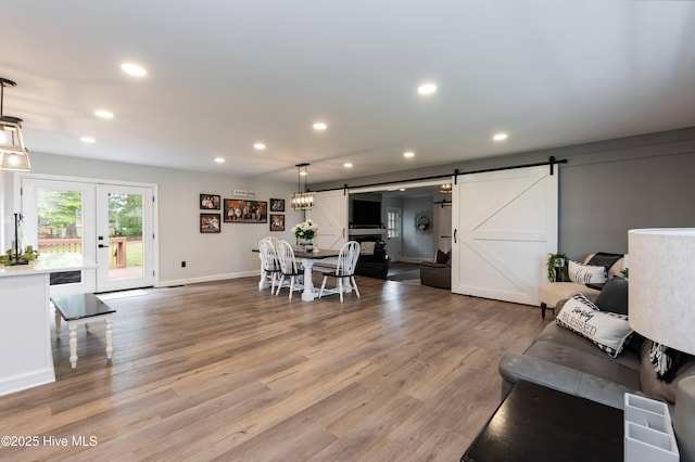 103 Midway Ln, Roanoke Rapids, NC 27870 - living room featuring a barn door, recessed lighting, light wood-style floors, baseboards, and french doors