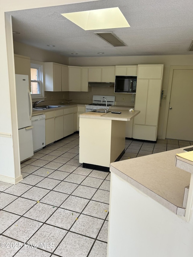 106 Eagle Ln, Hampstead, NC 28443 - kitchen featuring white appliances, a center island with sink, light countertops, a sink, and a textured ceiling