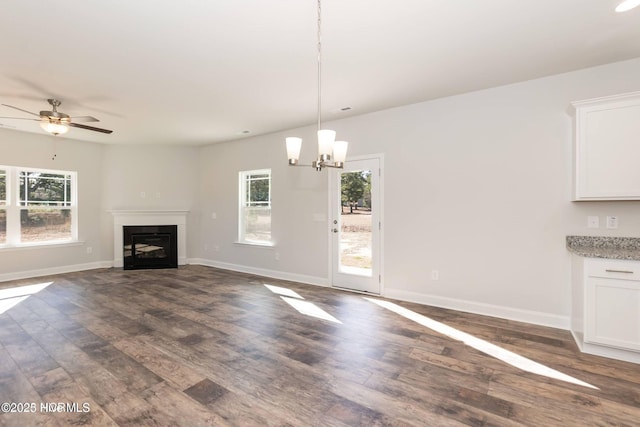 2986 Lyndhurst Ter SW, Shallotte, NC 28470 - unfurnished living room featuring dark wood-style floors, healthy amount of natural light, and baseboards