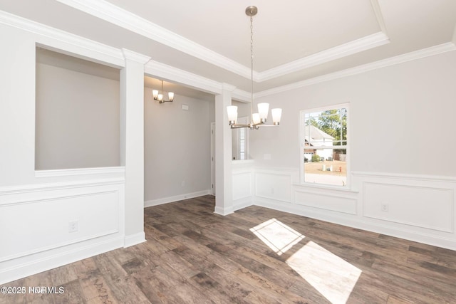 2986 Lyndhurst Ter SW, Shallotte, NC 28470 - unfurnished dining area featuring a chandelier, dark wood-type flooring, crown molding, ornate columns, and a wainscoted wall