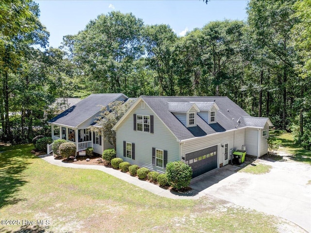 547 Deer Run Rd, New Bern, NC 28562 - view of front facade with driveway, a front yard, a garage, view of wooded area, and covered porch