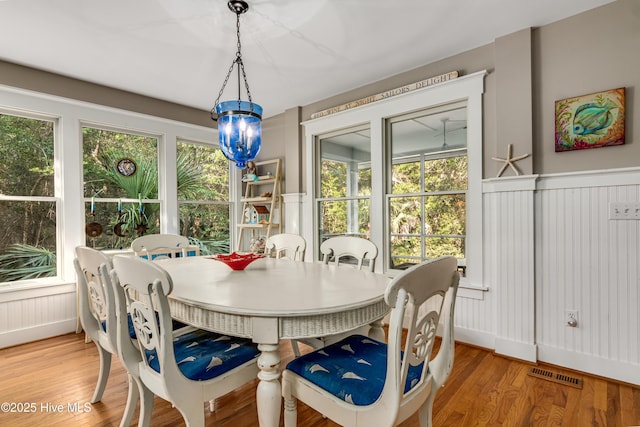 20 Fort Holmes Trl, Bald Head Island, NC 28461 - dining space featuring light wood-style floors, a decorative wall, and a wainscoted wall