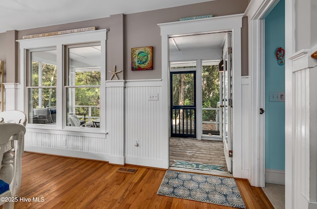 20 Fort Holmes Trl, Bald Head Island, NC 28461 - doorway to outside featuring wood finished floors, a wainscoted wall, and a decorative wall