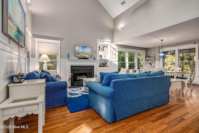20 Fort Holmes Trl, Bald Head Island, NC 28461 - living area with wood finished floors, a fireplace, high vaulted ceiling, and healthy amount of natural light