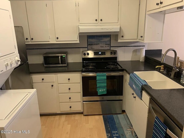 1904 E Fort Macon Rd Unit 269, Atlantic Beach, NC 28512 - kitchen featuring appliances with stainless steel finishes, stacked washing machine and dryer, under cabinet range hood, a sink, and white cabinetry