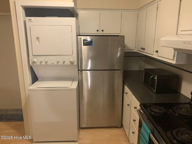 1904 E Fort Macon Rd Unit 269, Atlantic Beach, NC 28512 - kitchen featuring stainless steel appliances, stacked washer / drying machine, white cabinets, exhaust hood, and light wood-style flooring