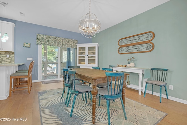 409 Womble St, Oak Island, NC 28465 - dining area with a chandelier, light wood-type flooring, and baseboards