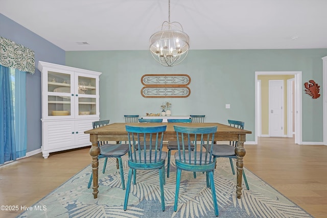 409 Womble St, Oak Island, NC 28465 - dining area with wood finished floors, a chandelier, and baseboards