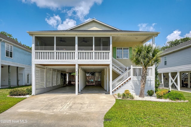 409 Womble St, Oak Island, NC 28465 - beach home with a sunroom, ceiling fan, driveway, and stairway