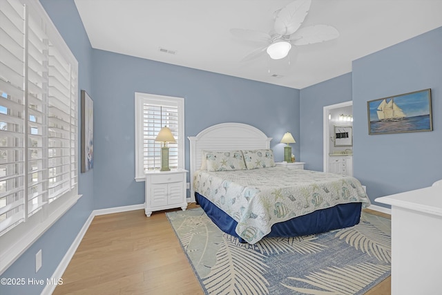 409 Womble St, Oak Island, NC 28465 - bedroom with wood finished floors, baseboards, ceiling fan, and ensuite bath
