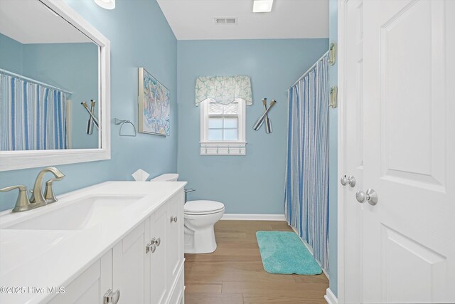 409 Womble St, Oak Island, NC 28465 - bathroom with wood finished floors, vanity, baseboards, toilet, and curtained shower