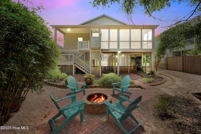 409 Womble St, Oak Island, NC 28465 - rear view of property with an outdoor fire pit, stairway, and a patio