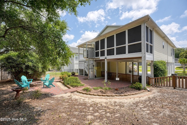 409 Womble St, Oak Island, NC 28465 - back of property with a fire pit, a patio area, a sunroom, and stairway