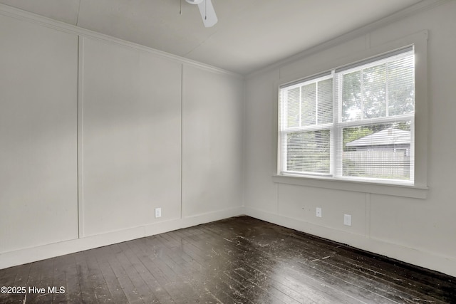 222 Evans St, Wilmington, NC 28405 - empty room featuring crown molding, dark wood-type flooring, a decorative wall, and ceiling fan