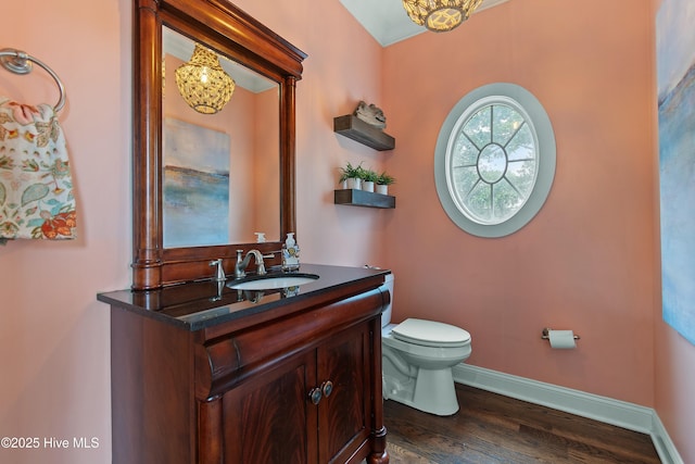 1086 Ferry Landing Dr SW, Supply, NC 28462 - half bathroom featuring a chandelier, vanity, toilet, wood finished floors, and baseboards