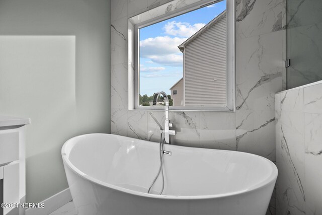 604 Willbrook Cir, Sneads Ferry, NC 28460 - full bathroom with marble finish floors, plenty of natural light, a freestanding tub, and baseboards