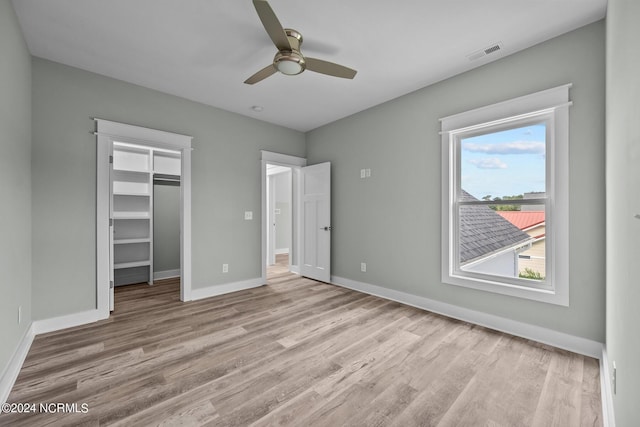 604 Willbrook Cir, Sneads Ferry, NC 28460 - unfurnished bedroom featuring multiple windows, wood finished floors, a walk in closet, and baseboards