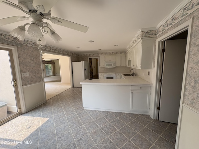 1608 Brices Creek Rd, New Bern, NC 28562 - kitchen featuring white appliances, a sink, wallpapered walls, a ceiling fan, and a peninsula