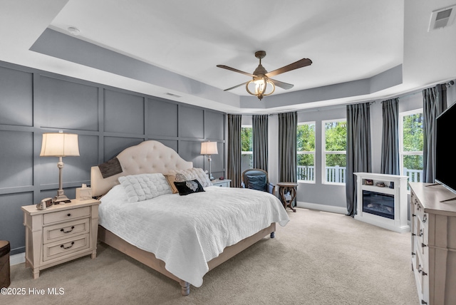 1700 Sun Palms Blvd SE, Bolivia, NC 28422 - bedroom with a decorative wall, light carpet, a raised ceiling, a glass covered fireplace, and baseboards