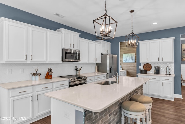 1700 Sun Palms Blvd SE, Bolivia, NC 28422 - kitchen with stainless steel appliances, a chandelier, decorative backsplash, a sink, and a breakfast bar area