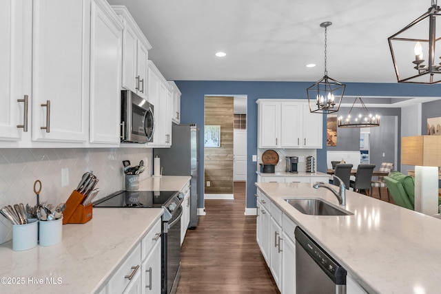 1700 Sun Palms Blvd SE, Bolivia, NC 28422 - kitchen featuring stainless steel appliances, a sink, a chandelier, white cabinets, and dark wood-style flooring