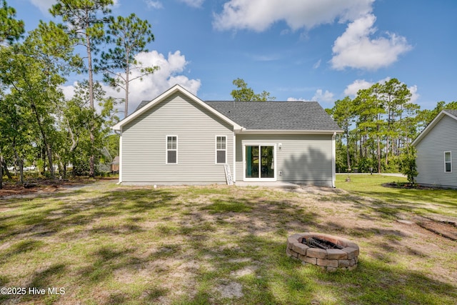 1858 E Boiling Spring Rd, Southport, NC 28461 - back of house featuring an outdoor fire pit, a yard, and roof with shingles
