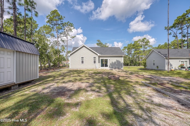 1858 E Boiling Spring Rd, Southport, NC 28461 - back of property featuring a fire pit and a yard
