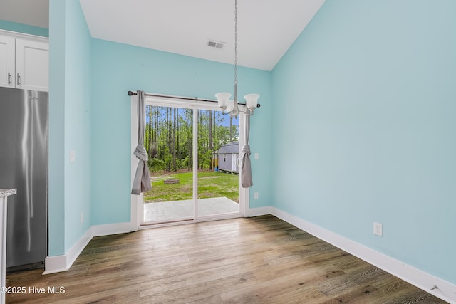 1858 E Boiling Spring Rd, Southport, NC 28461 - unfurnished dining area featuring a chandelier, wood finished floors, baseboards, and lofted ceiling