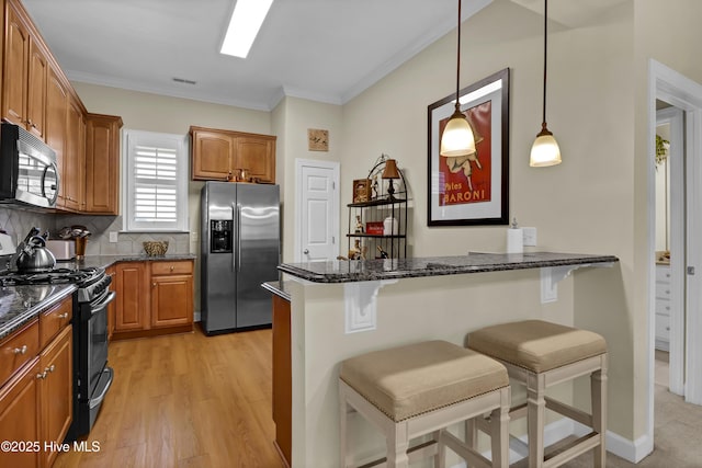644 Village Park Dr Unit 207, Wilmington, NC 28405 - kitchen with stainless steel fridge with ice dispenser, black gas range, a breakfast bar area, a peninsula, and ornamental molding