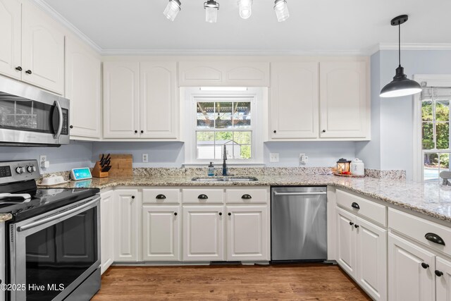 105 Teal Pointe Dr, Pikeville, NC 27863 - kitchen featuring stainless steel appliances, a sink, white cabinets, crown molding, and light wood finished floors