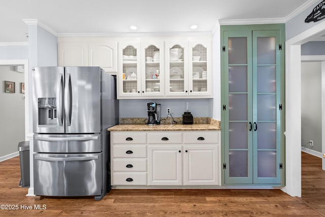 105 Teal Pointe Dr, Pikeville, NC 27863 - kitchen with stainless steel refrigerator with ice dispenser, ornamental molding, light stone countertops, glass insert cabinets, and white cabinets