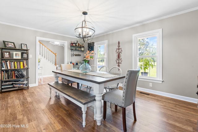 105 Teal Pointe Dr, Pikeville, NC 27863 - dining area featuring a chandelier, stairway, light wood finished floors, baseboards, and crown molding