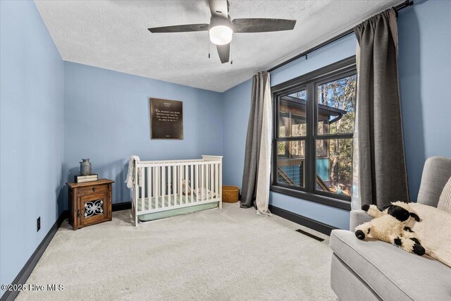 105 Tartan Trl, Southern Pines, NC 28387 - bedroom with carpet, a textured ceiling, a crib, and ceiling fan